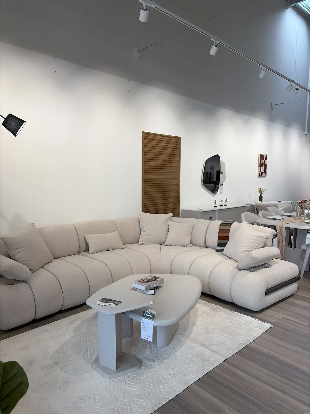 Un canapé d'angle crème et sa table basse dans le showroom Mobela d'Allonnes